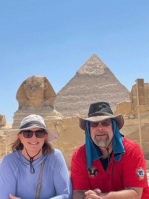 艾伦·阿斯伯里和她丈夫站在狮身人面像和金字塔前